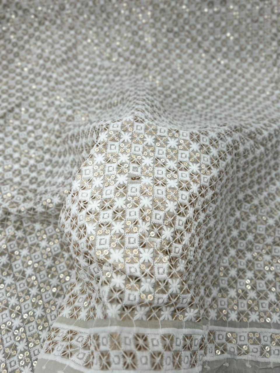 Close-up of a textured fabric with intricate patterns and beadwork.