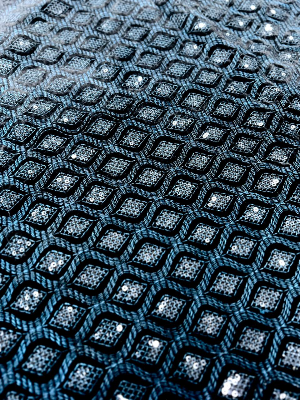 Close-up view of premium teal blue velvet fabric with heavy thread embroidery and sequin detailing.