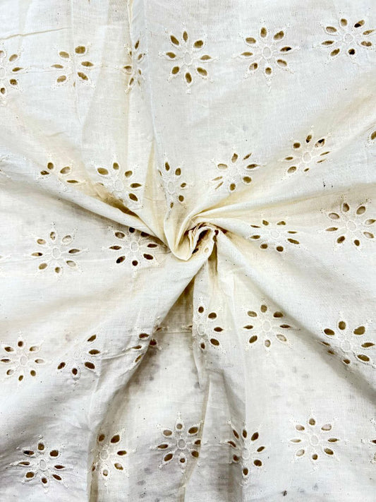 Close-up of dyeable ivory cotton textile featuring an elegant all-over flower cutwork pattern (Hakoba), 44 inches wide.