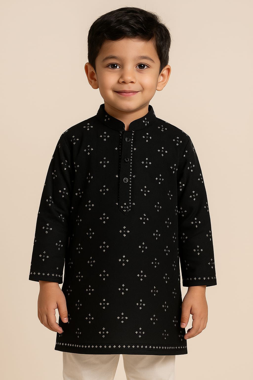 Young boy wearing a black kurta with white patterns on a beige background