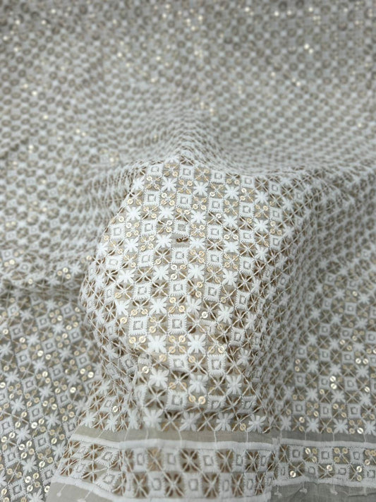 Close-up of a textured fabric with intricate patterns and beadwork.