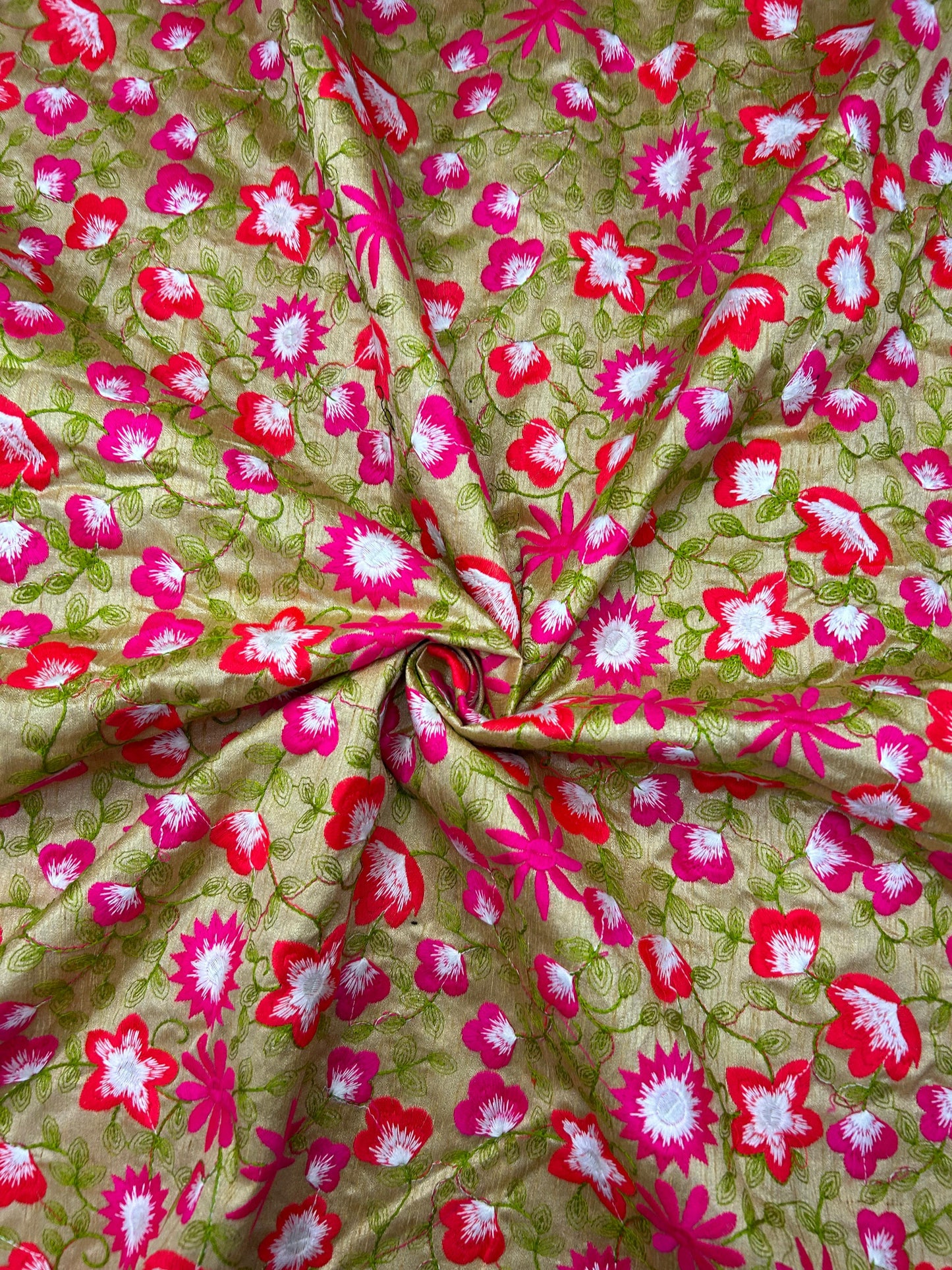 Floral brocade silk textile featuring vibrant pink flowers on a green base.