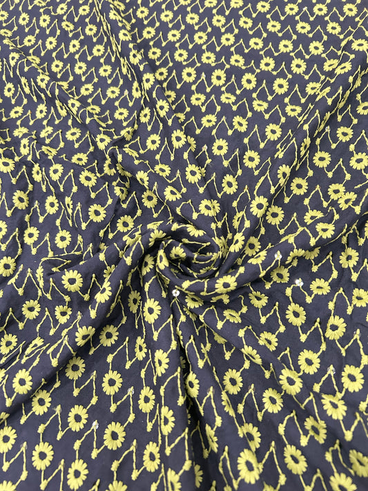 Black and yellow daisy print fabric – soft, lightweight apparel material for dresses and kurta designs.