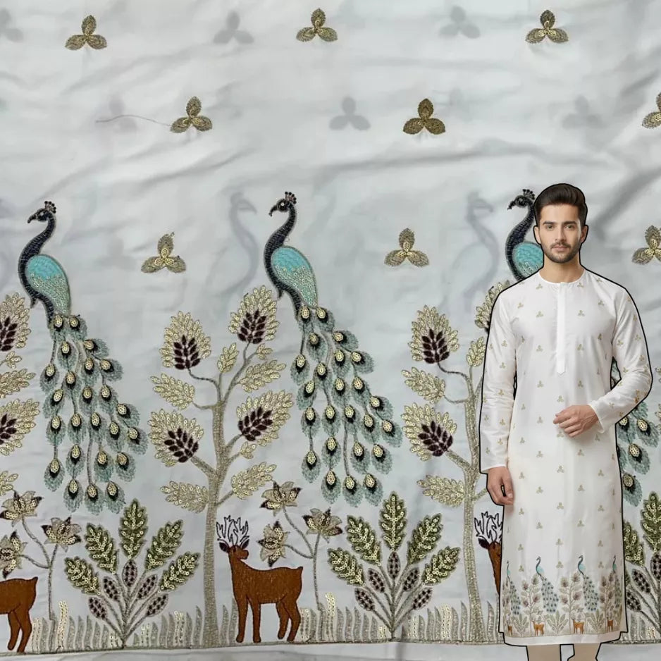Ivory satin kurta fabric featuring heavy peacock border embroidery with sequins, trees and deer motifs for festive and wedding wear.