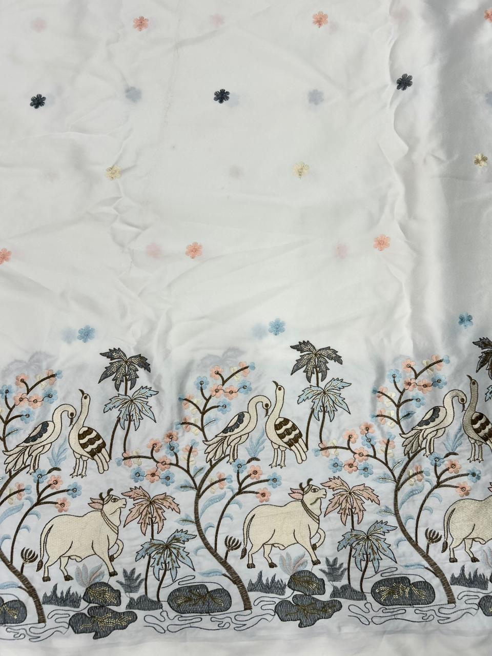 Premium ivory malai satin kurta fabric showcasing pastel cow and bird embroidery with elegant daman border for celebrations