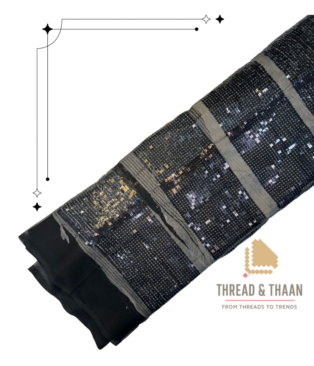 Premium black net fabric with dazzling gold sequin embroidery in a modern checkerboard stripe pattern, perfect for designer lehengas and party gowns.