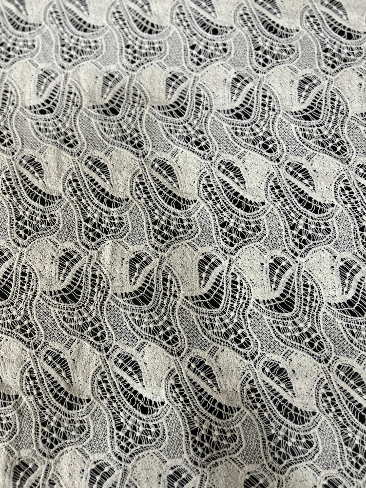 Premium white lace jacquard net fabric with wave-pattern cutwork — ideal for tops, dresses, overlays and designer outfits.