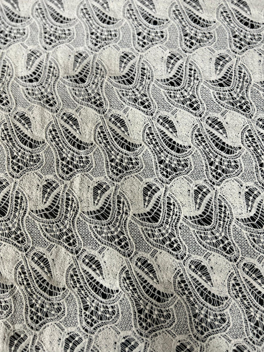 Premium white lace jacquard net fabric with wave-pattern cutwork — ideal for tops, dresses, overlays and designer outfits.