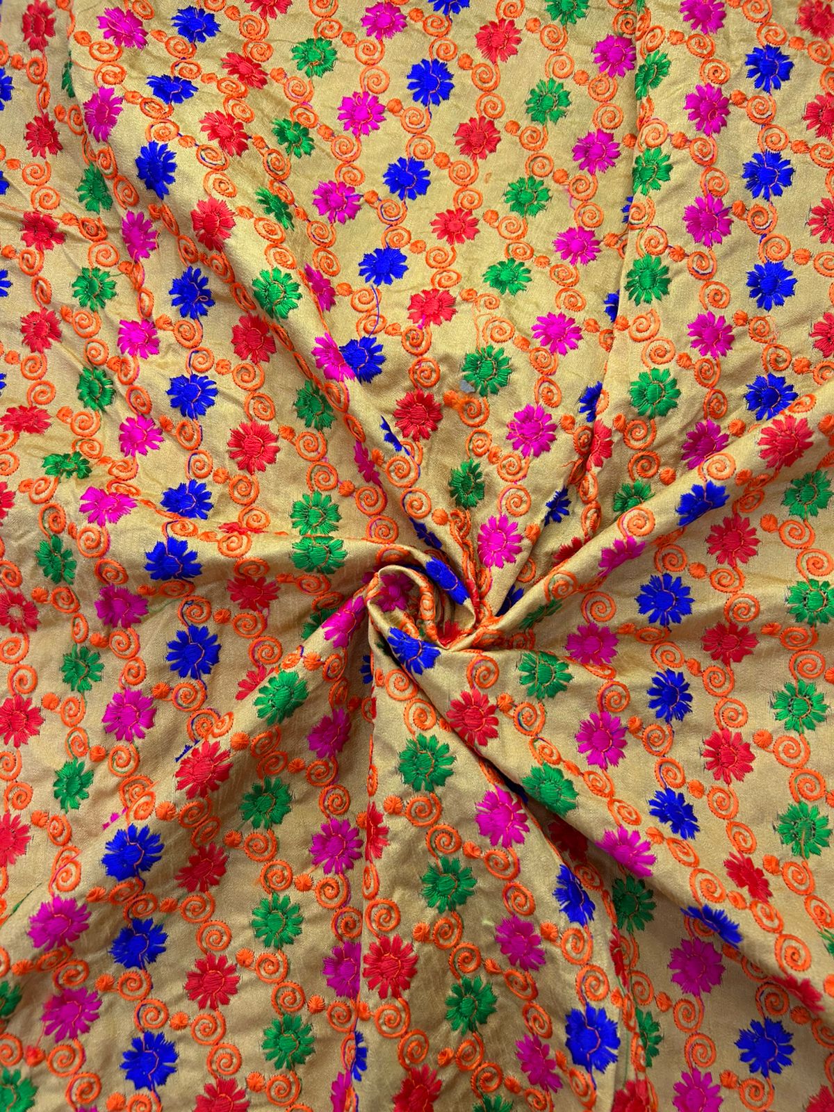 Premium silk brocade textile featuring colorful floral embroidery on beige base.