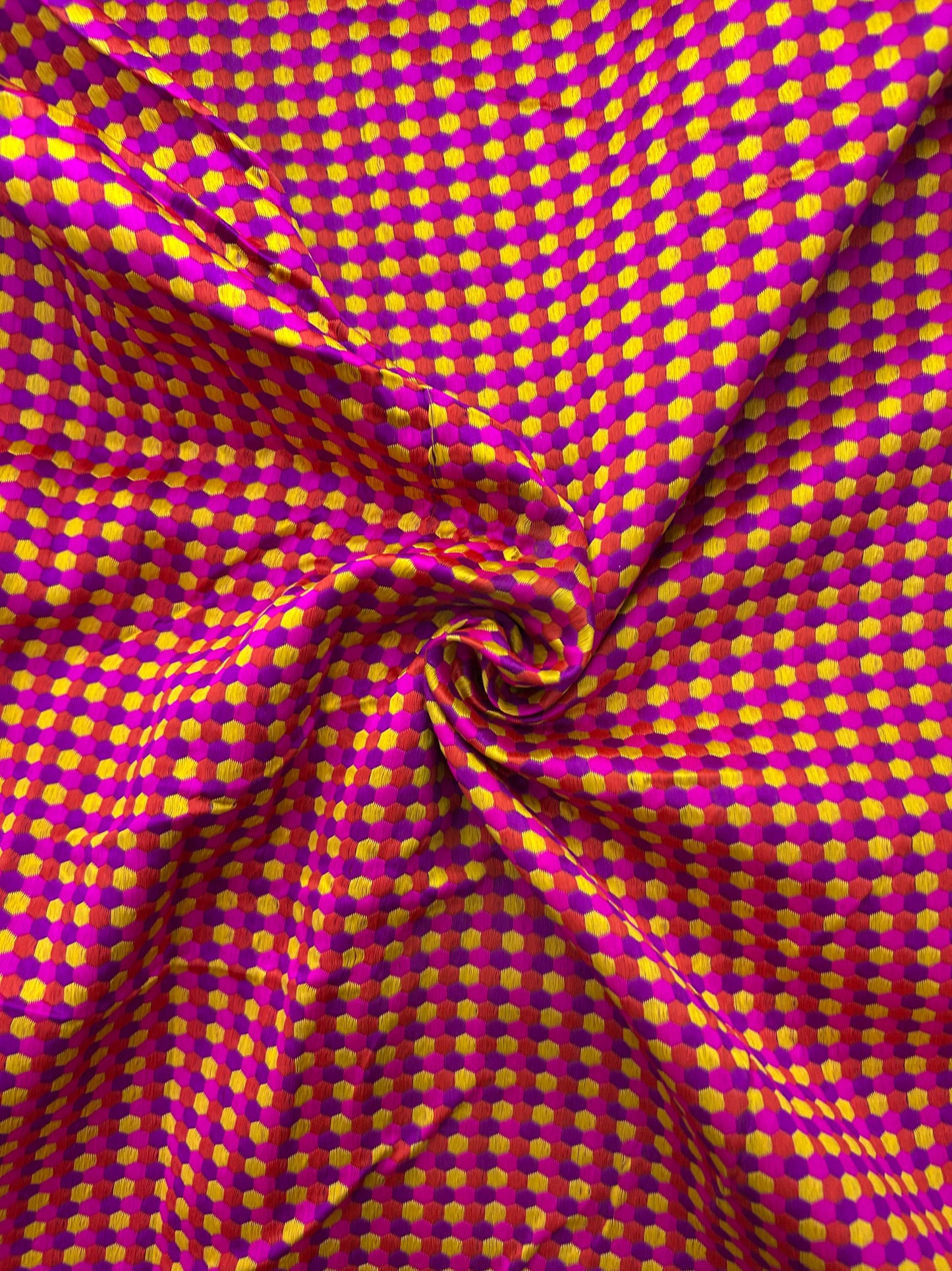 Premium polka dot brocade silk textile in pink and yellow for festive outfits.