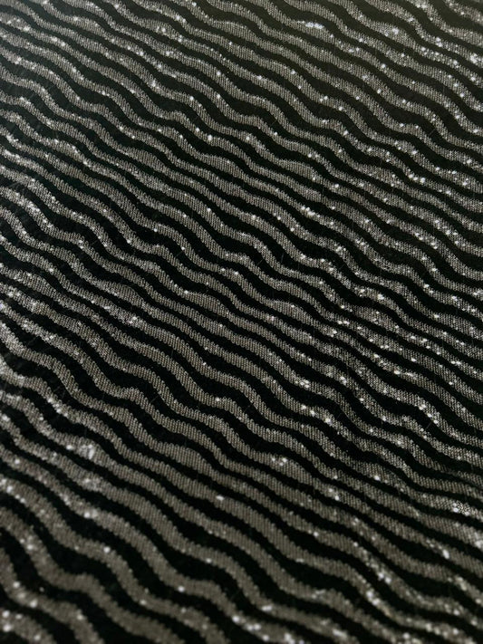 Premium black velvet fabric with metallic wavy pattern for designer garments.