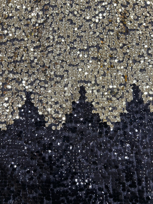 Close-up of dazzling black net textile with two-toned gold and black sequins, creating a shimmering, shifting effect for designer party wear.