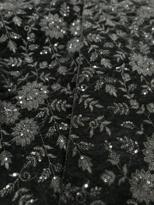 Close up view of black velvet fabric with intricate floral embroidery work, luxury textile for sherwani, jackets, blazers and suits