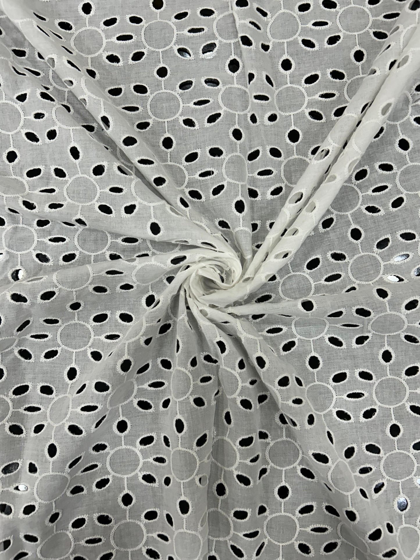 Close-up of beautiful white embroidered cotton textile for ethnic wear and fashionable Indo-Western dresses.