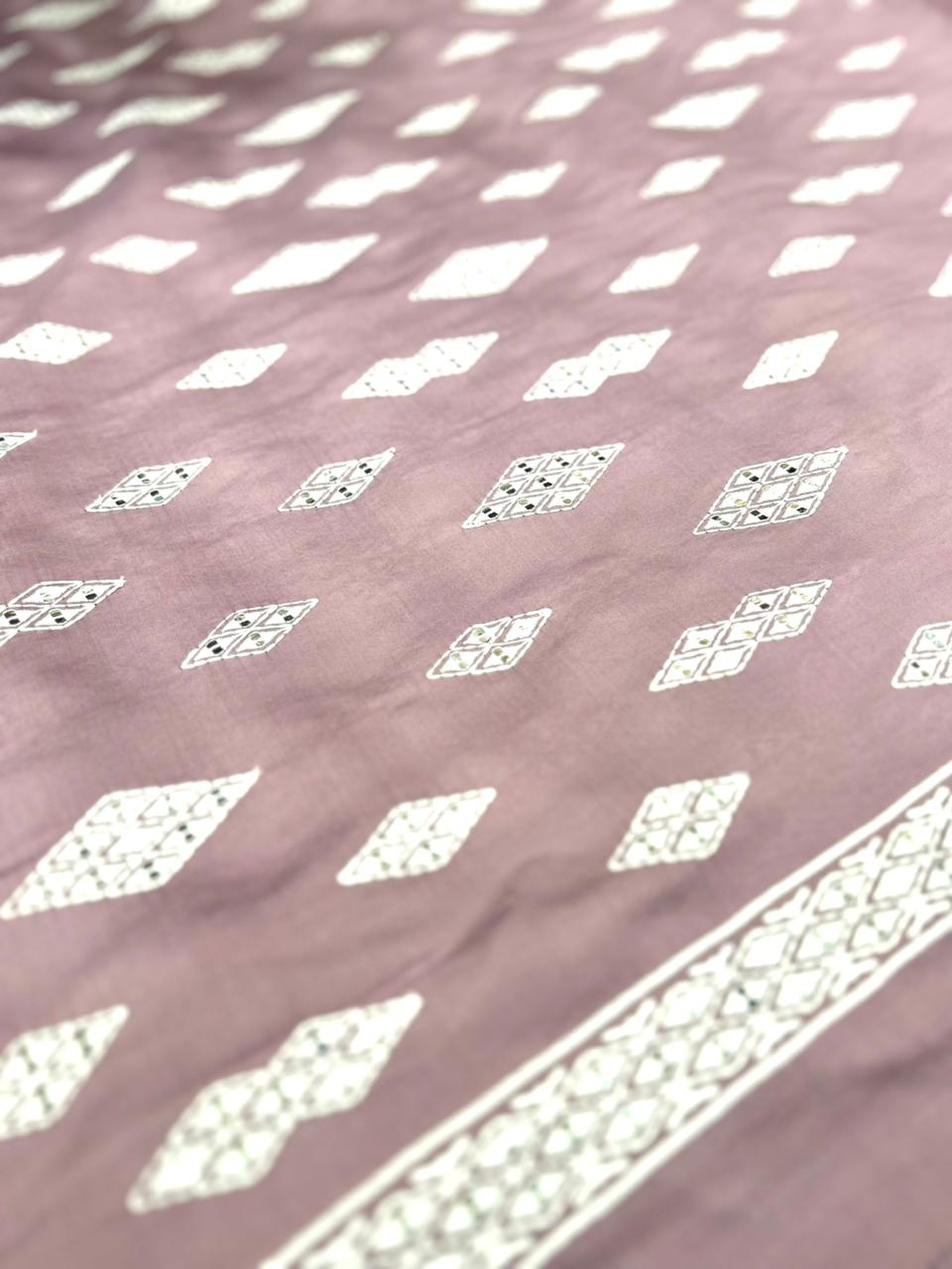 Patterned fabric with white geometric designs on a pink background.