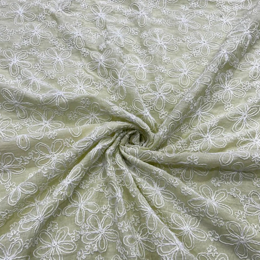 Close-up of Pastel Green Mal Chanderi fabric with white floral embroidery.