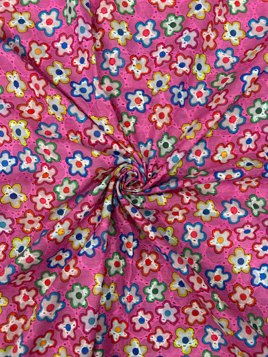 Close-up of breathable 100% cotton textile with bright pink background and cheerful embroidered flower cutouts, ideal for kurtas.