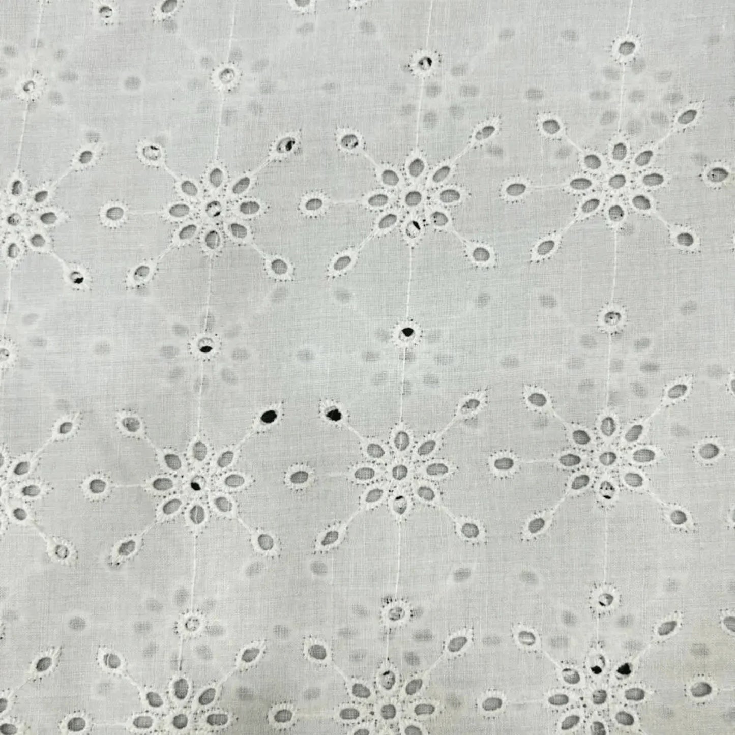 Premium White Hakoba Schiffli Cotton Fabric with elegant floral eyelet embroidery. Soft breathable cotton fabric in 56 inch width, ideal for kurtis, dresses, tops, co-ord sets, kidswear, blouses and ethnic wear.
