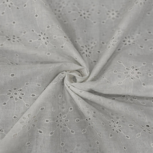 Premium White Hakoba Schiffli Cotton Fabric featuring elegant geometric floral eyelet embroidery. Soft breathable cotton fabric with intricate all-over embroidery, 56 inch width, ideal for kurtis, dresses, tops, co-ord sets, kidswear and ethnic wear.