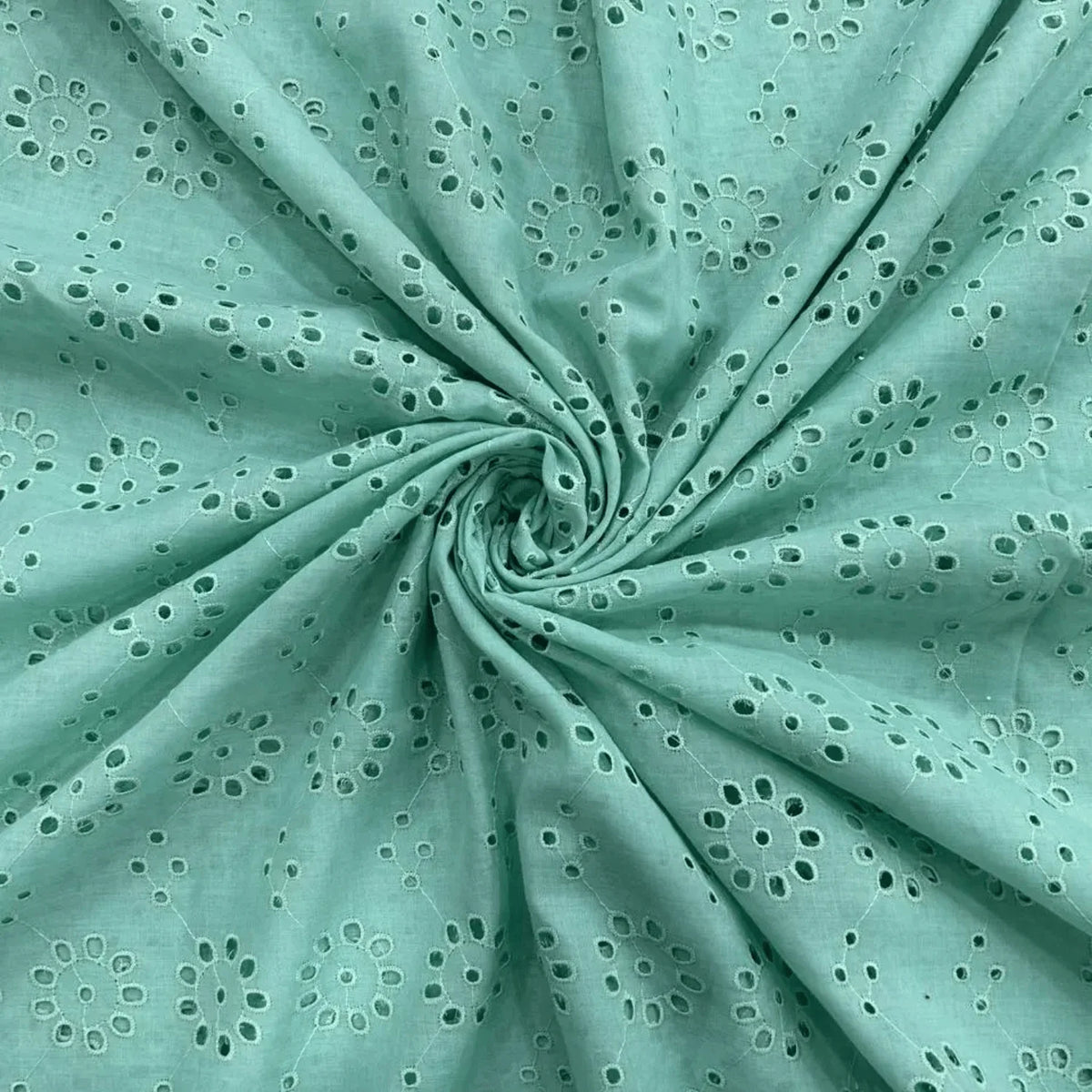 Sea Green Hakoba Schiffli fabric featuring elegant floral cutwork embroidery on soft breathable cotton, ideal for kurtis, dresses, tops and kidswear.