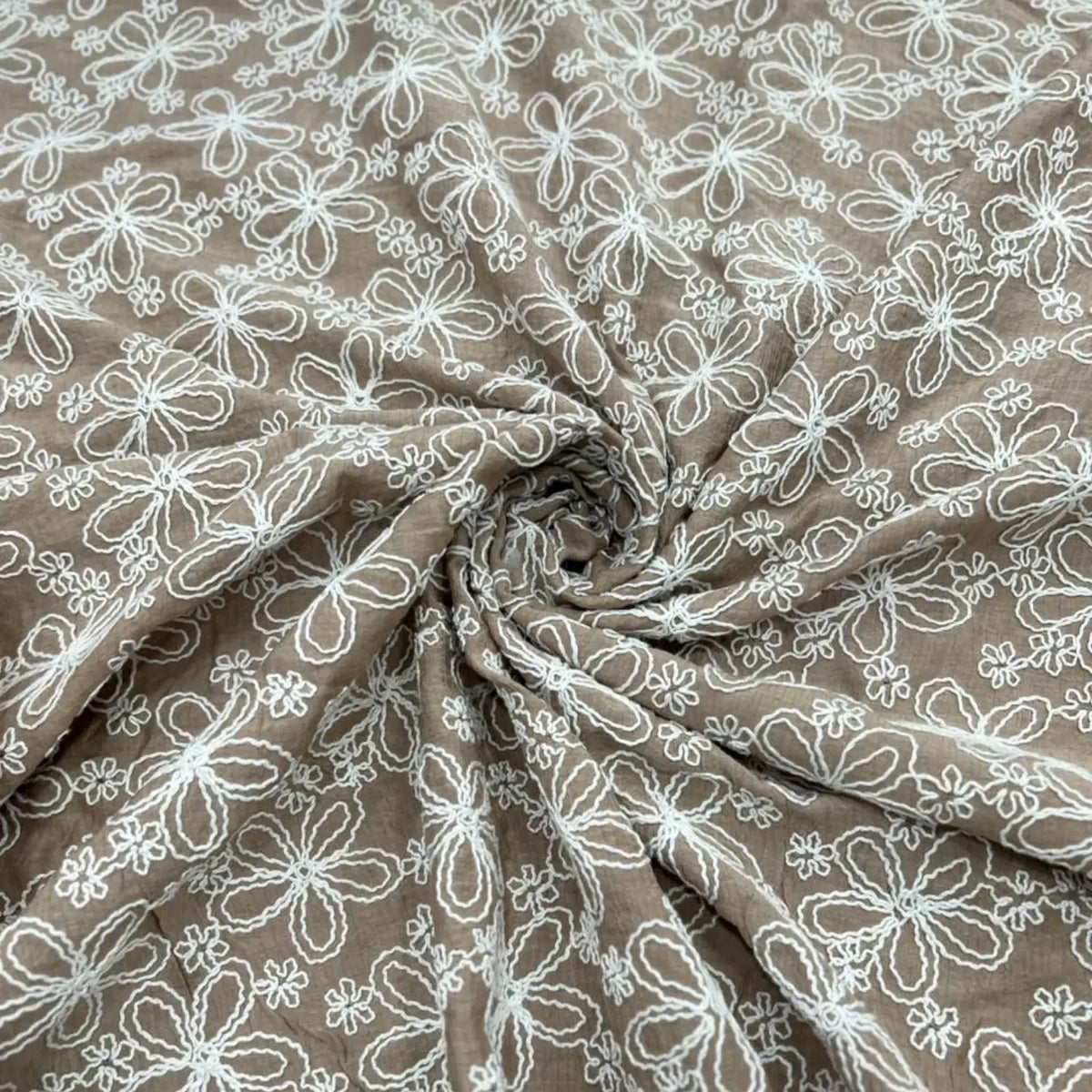Close-up of Taupe Brown Mal Chanderi fabric featuring elegant white floral thread embroidery in a spiral drape, highlighting the lightweight texture, intricate craftsmanship, and premium finish.