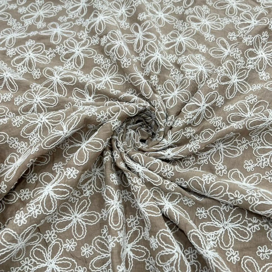 Close-up of Taupe Brown Mal Chanderi fabric featuring elegant white floral thread embroidery in a spiral drape, highlighting the lightweight texture, intricate craftsmanship, and premium finish.