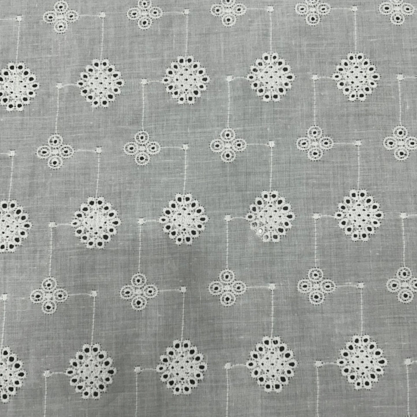 Premium white Hakoba cotton Schiffli embroidery fabric featuring elegant geometric floral eyelet pattern. Soft, breathable 100% cotton fabric with 56-inch width, ideal for kurtis, dresses, co-ord sets, kidswear, tops and ethnic wear.