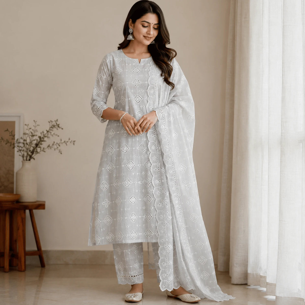Woman wearing a premium white Hakoba cotton Schiffli kurti set featuring elegant geometric embroidery. Soft, breathable 100% cotton fabric with 56-inch width, ideal for ethnic wear, kurtis, dupattas, palazzos and festive outfits.