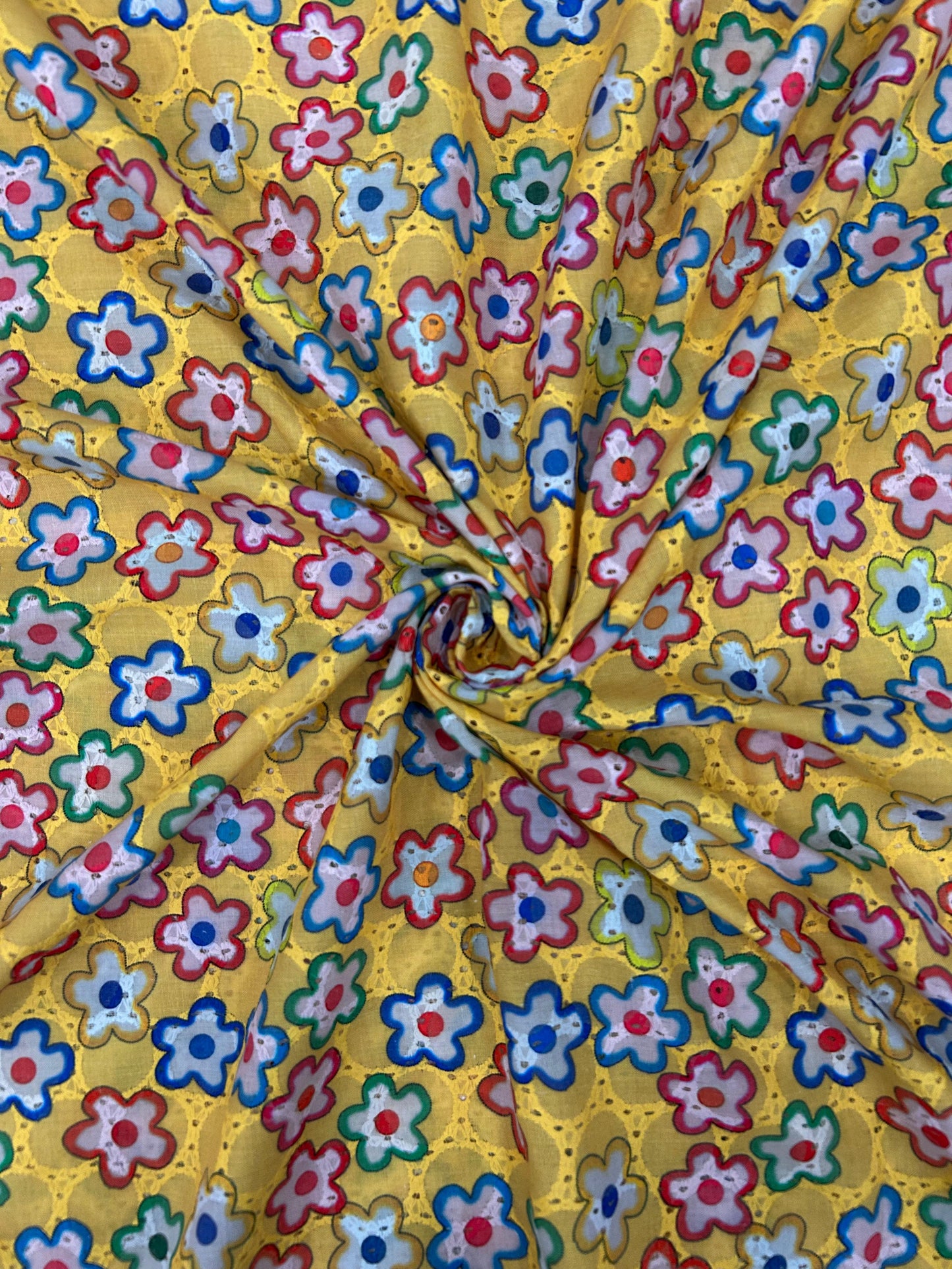 Close-up of breathable 100% cotton textile with yellow background and bright multicolor flower embroidery, ideal for festive kurtas.